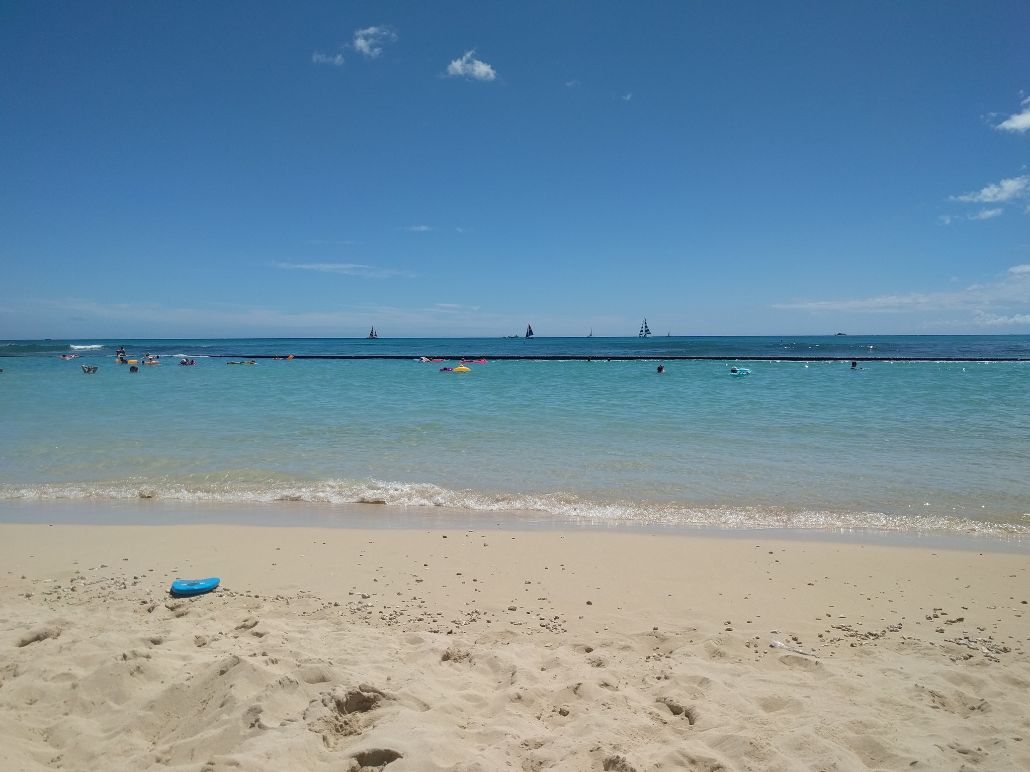 Boats NOT dropping off the horizon at a beach.